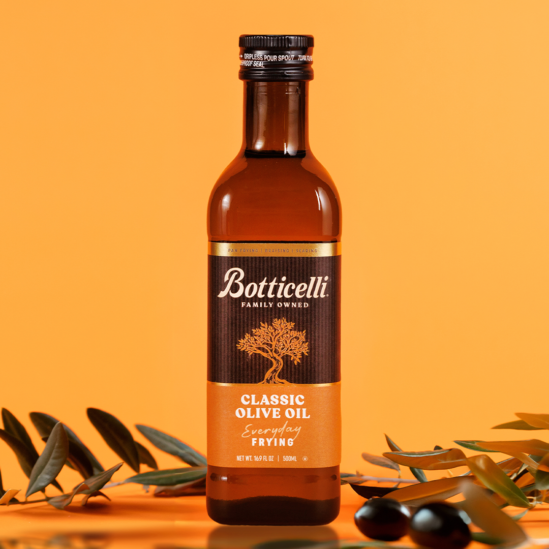 Bottle of Botticelli olive oil with olive branches on an orange background