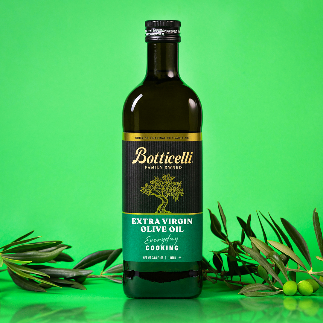Bottle of Botticelli cooking extra virgin olive oil on a green background with olive branches.