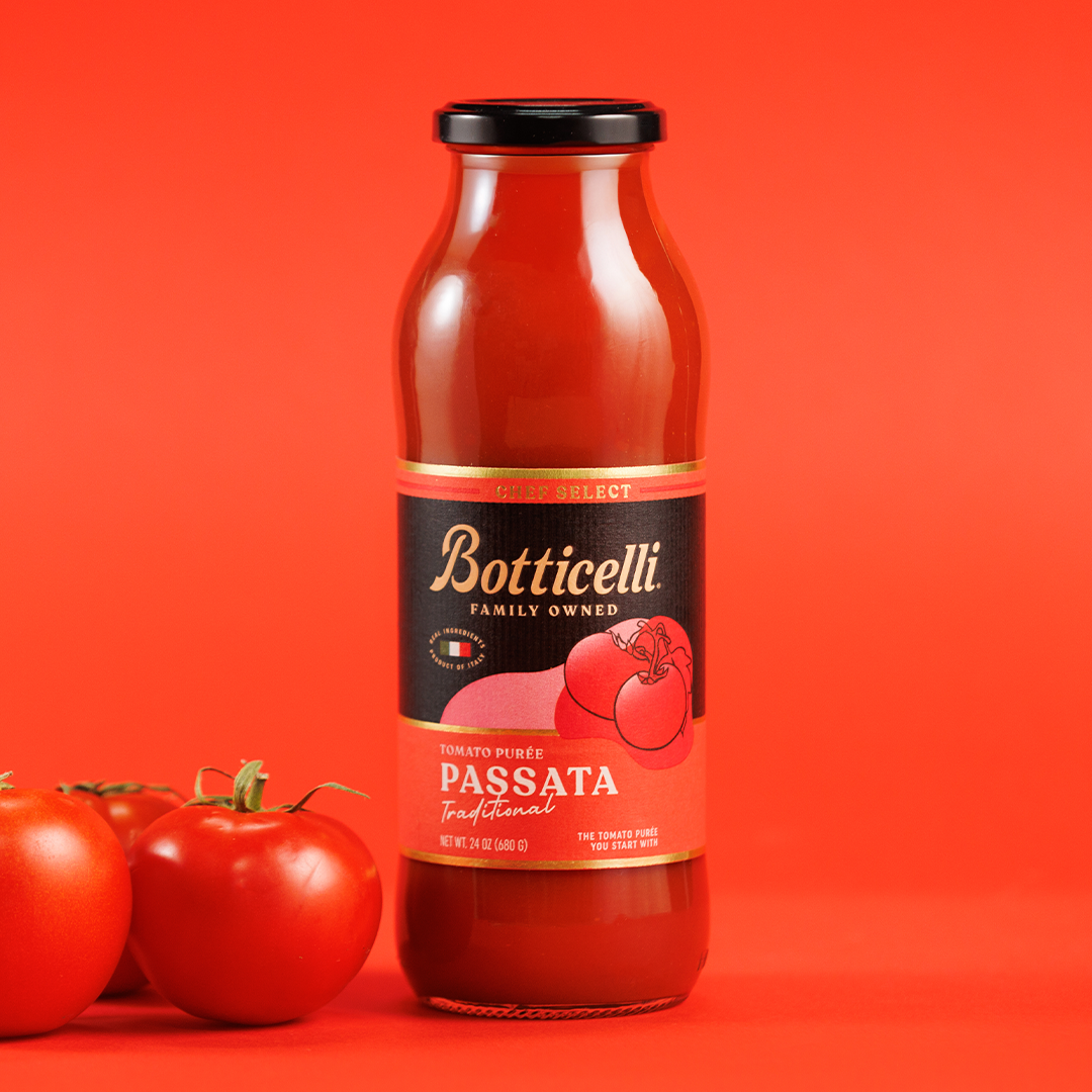 Bottle of Botticelli Passata with tomatoes on a red background