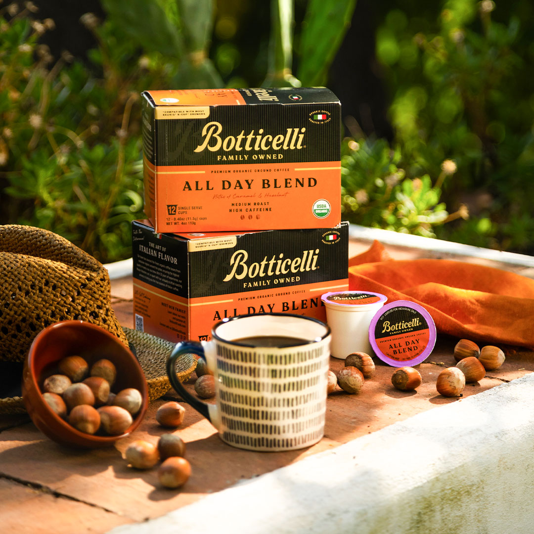 Botticelli coffee packaging with a cup of coffee and coffee beans on a wooden surface.