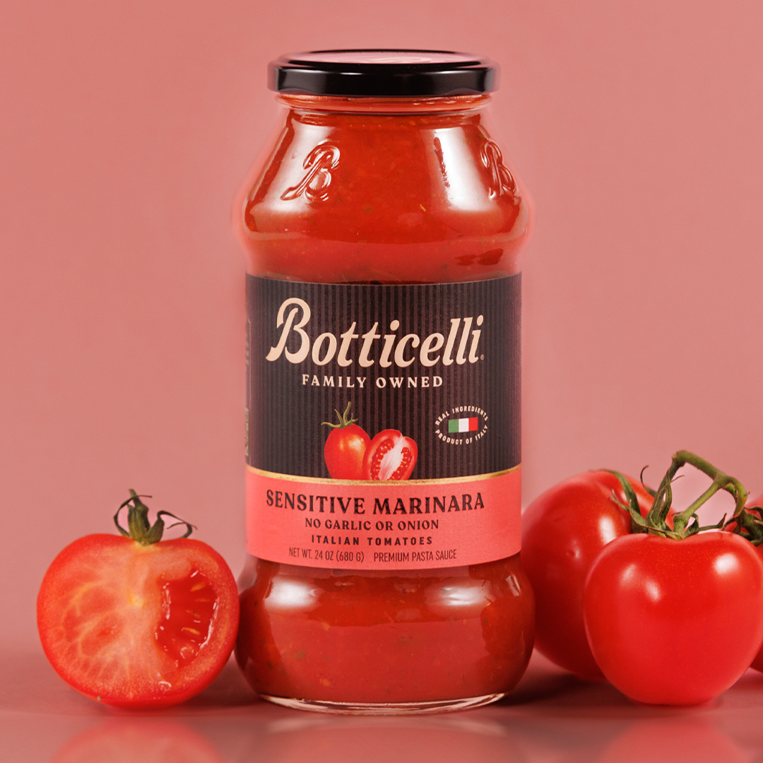 Botticelli pasta sauce jar with tomatoes on a pink background