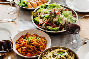 a dinner table set with Italian food for serving