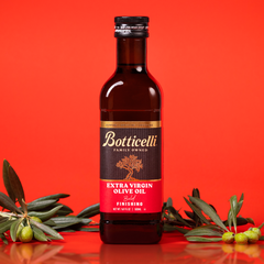 Bottle of Botticelli finishing extra virgin olive oil on a red background with olive branches.