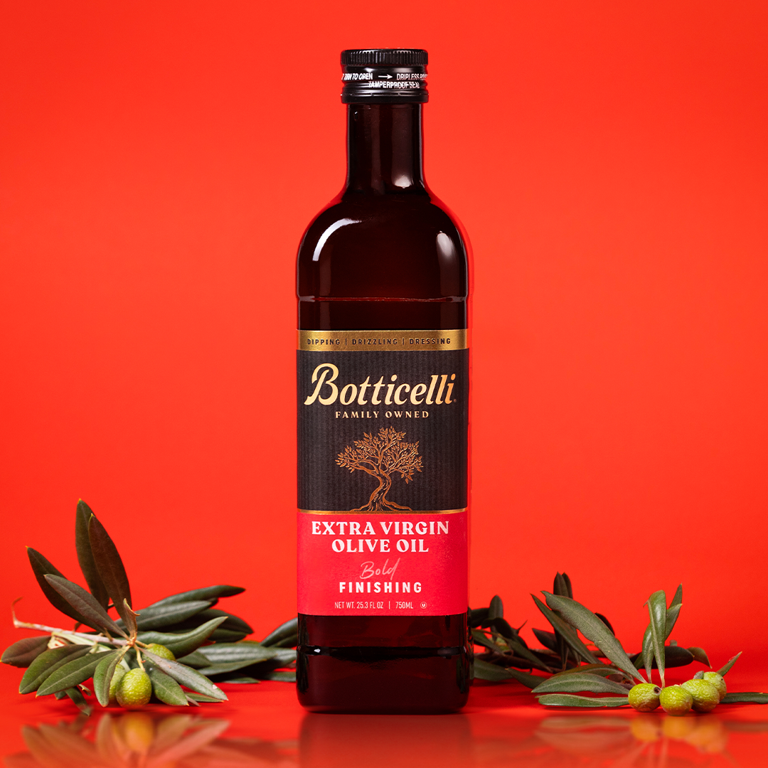Bottle of Botticelli finishing extra virgin olive oil on a red background with olive branches.