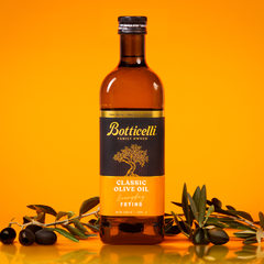 Bottle of Botticelli frying olive oil with olives on an orange background