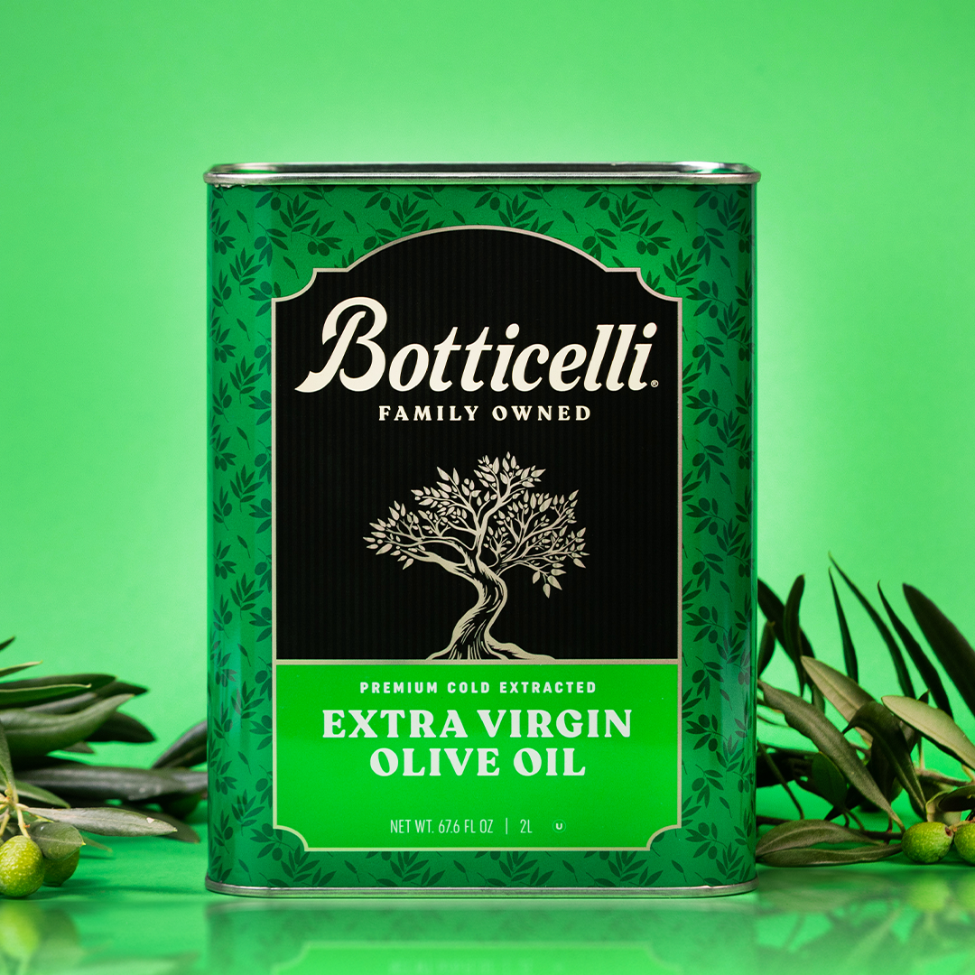 Botticelli Extra Virgin Olive Oil Tin with green leaves on a green background