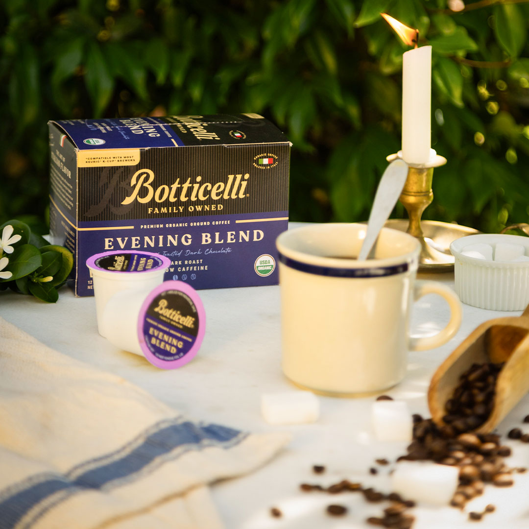 Botticelli Evening Blend coffee packaging with a cup, spoon, and coffee beans on a table.