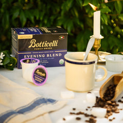 Botticelli Evening Blend coffee packaging with a cup, spoon, and coffee beans on a table.