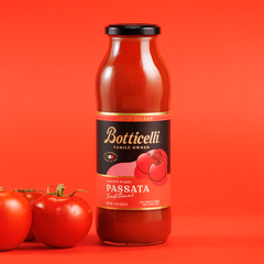 Bottle of Botticelli Passata with tomatoes on a red background
