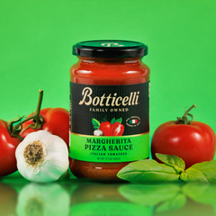 Botticelli Margherita Pizza Sauce jar with tomatoes, garlic, and basil on a green background