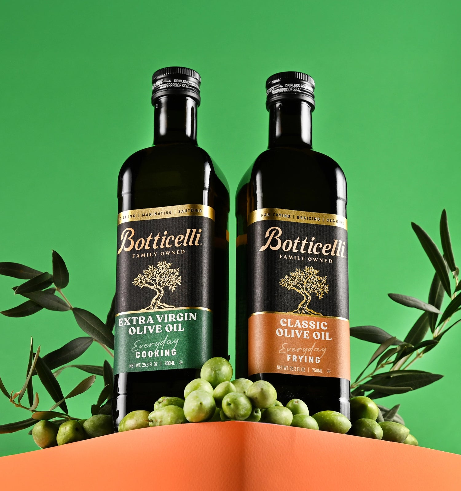 Two bottles of Botticelli olive oil with olive branches and green olives on a green background