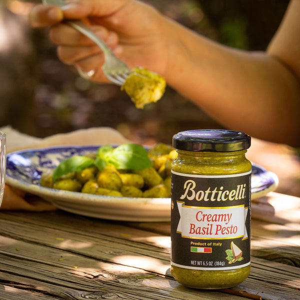 Someone eating gnocchi with creamy basil pesto 