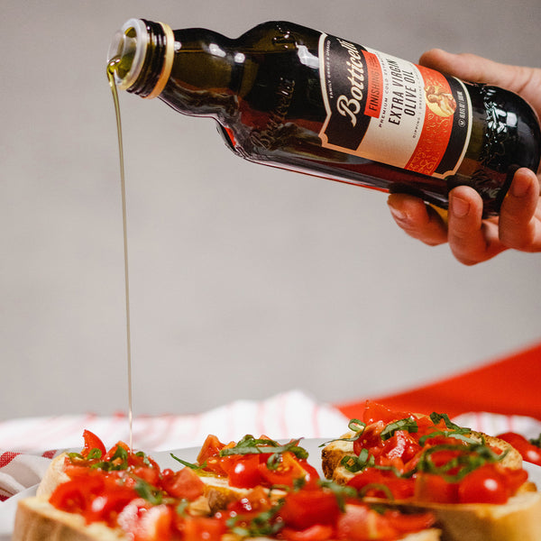 finishing extra virgin olive oil drizzled on bruschetta